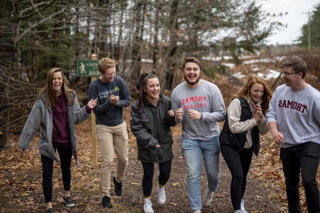 Thomas college male and female students laughing and hiking